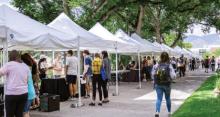 Photo of students visiting resource fair tents on campus. 