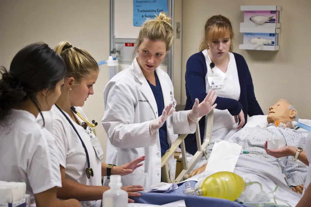 Nursing instructor working with students in lab